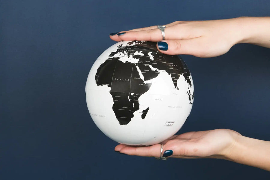 Black and white globe held by hands.